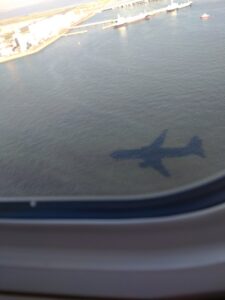 飛行機の機影が海上に映る
